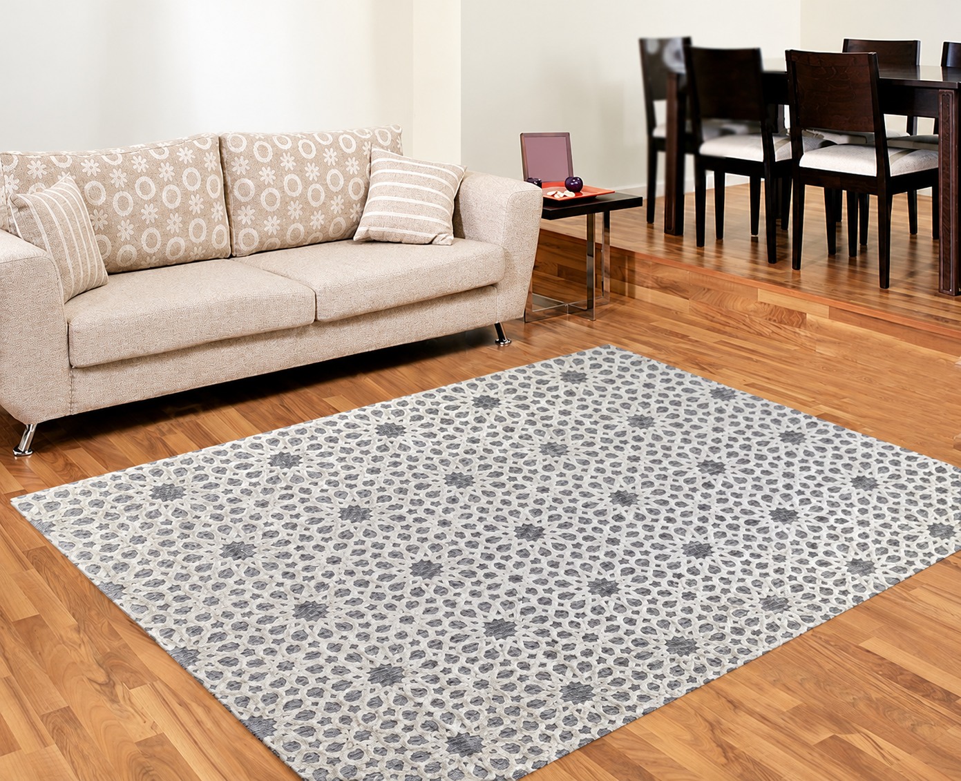 A patterned grey and ivory rug beside a sofa