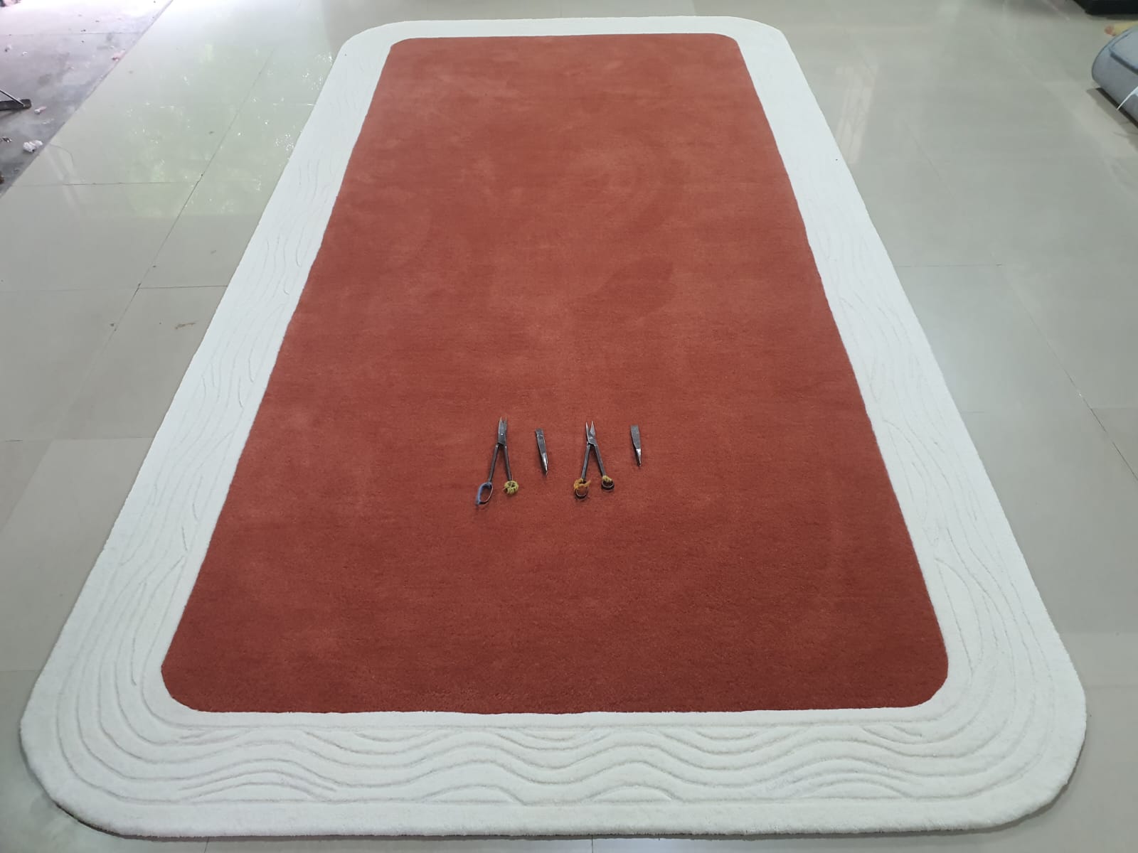 Artisans working on a large round abstract rug